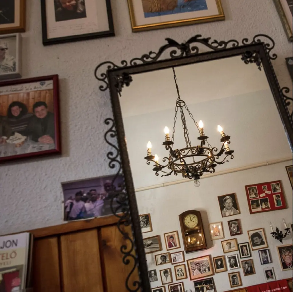 A Kádár Étkezde fala a Klauzál téren: bekeretezett fotók, falióra és csillár a tükörben